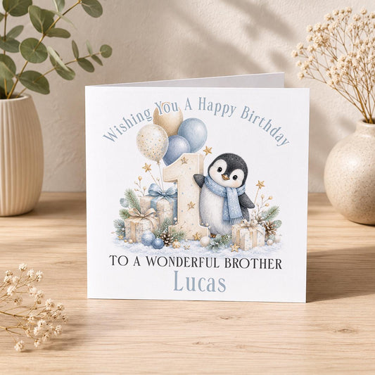 Personalised penguin 1st birthday card – penguin in a blue scarf with a number 1, To a Wonderful Brother Lucas