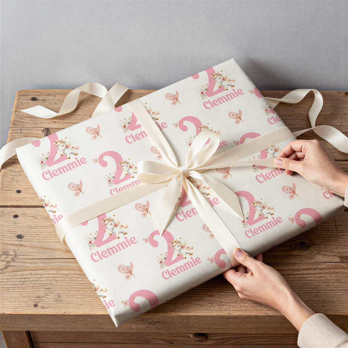 Personalised pink unicorn wrapping paper rolled and shown against a plain background
