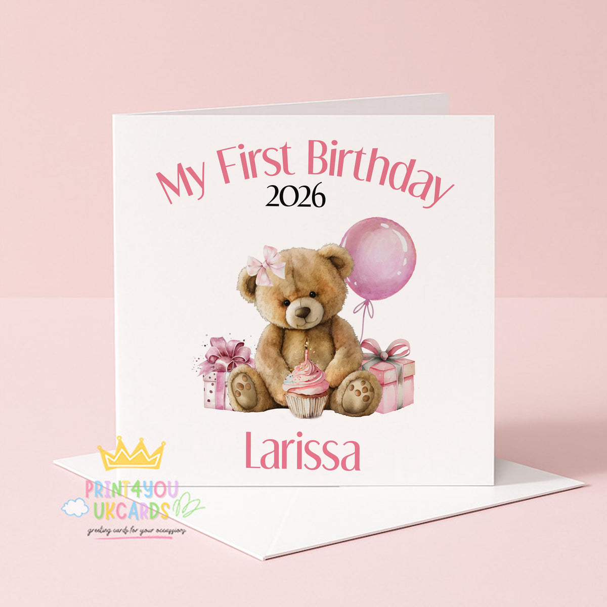 Square pink first birthday card featuring a teddy bear design, shown personalised with a name and year