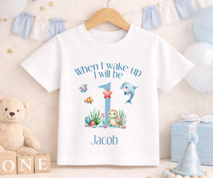 Baby wearing a personalised under the sea first birthday outfit with a custom name printed on soft cotton.