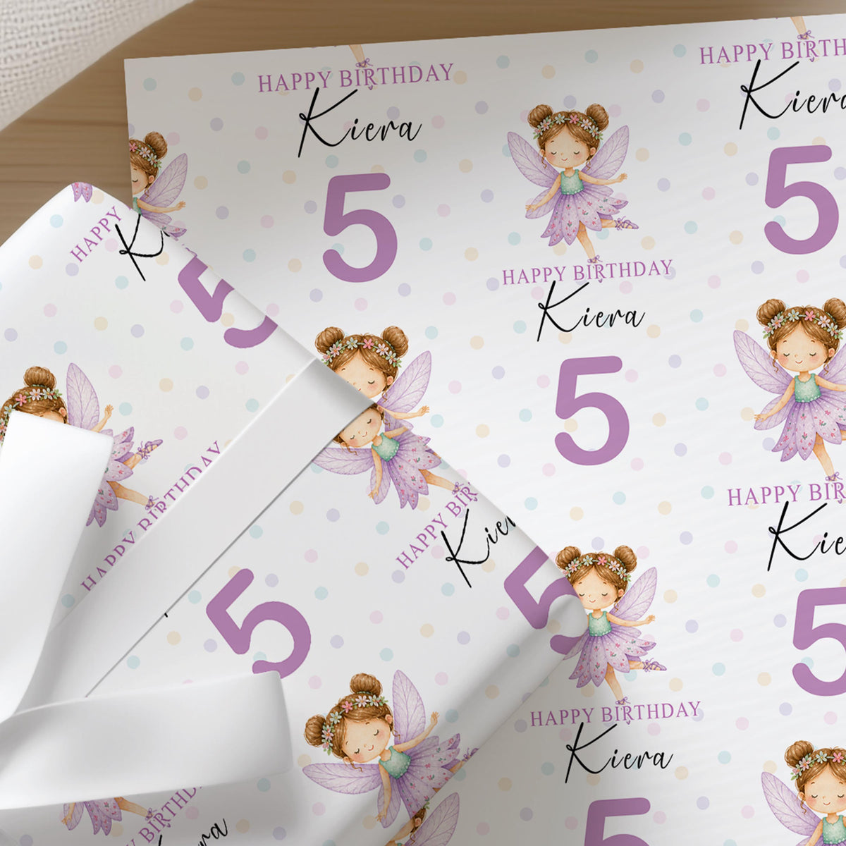 Personalised fairy wrapping paper printed with a custom name and age, shown as a full sheet