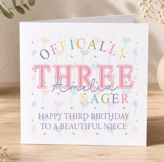 Personalised third birthday card featuring colourful Officially Three text and illustrations, shown with a personalisation example for a niece named Amelia