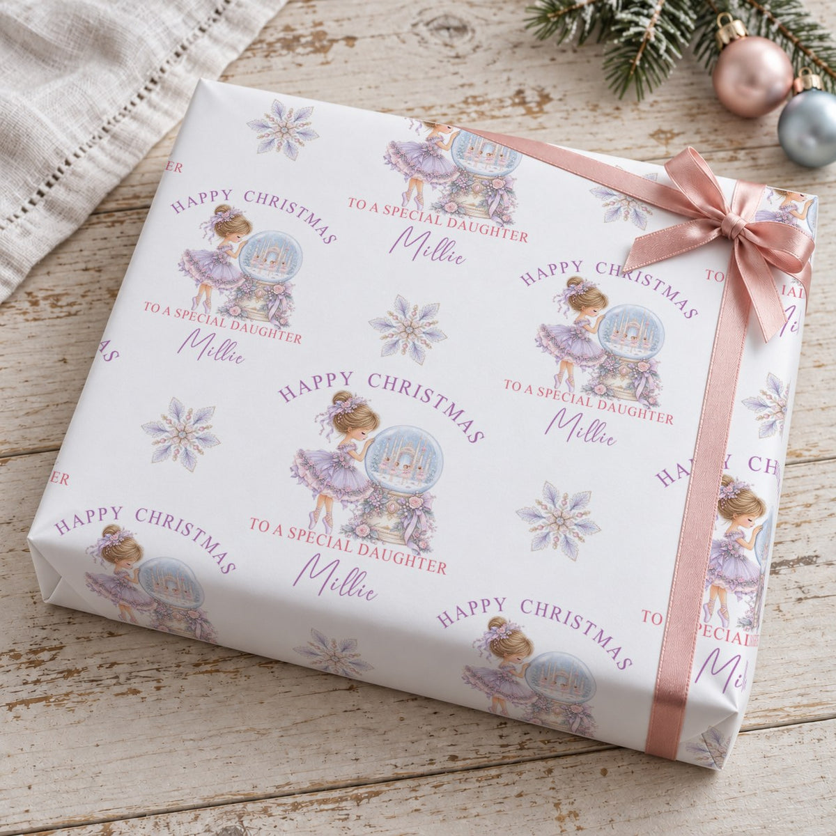 Gift wrapped in personalised ballerina Christmas wrapping paper tied with a rose pink satin bow
