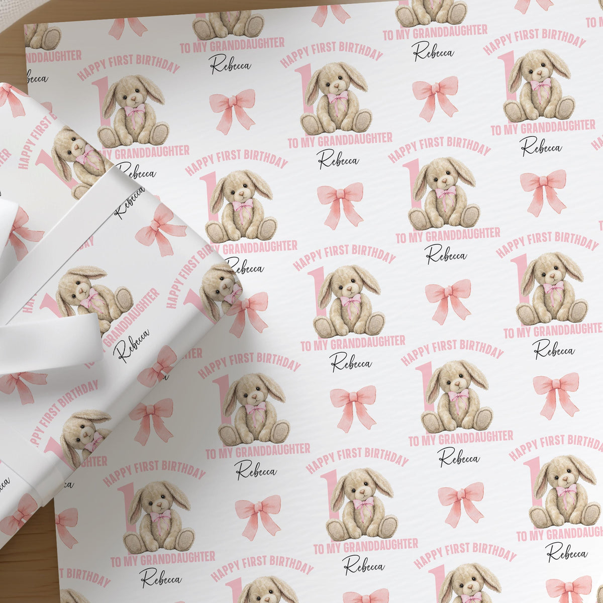 Personalised pink rabbit wrapping paper printed with a custom name and relation for a baby girl's first birthday