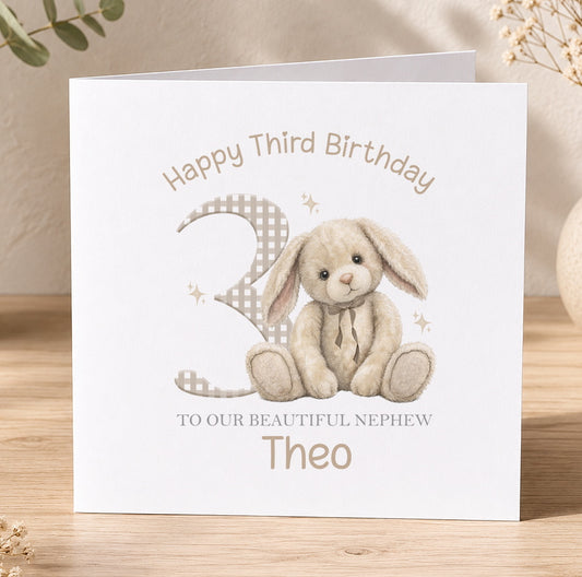 Square personalised birthday card featuring a soft beige bunny illustration with the child's name and age printed on the front.