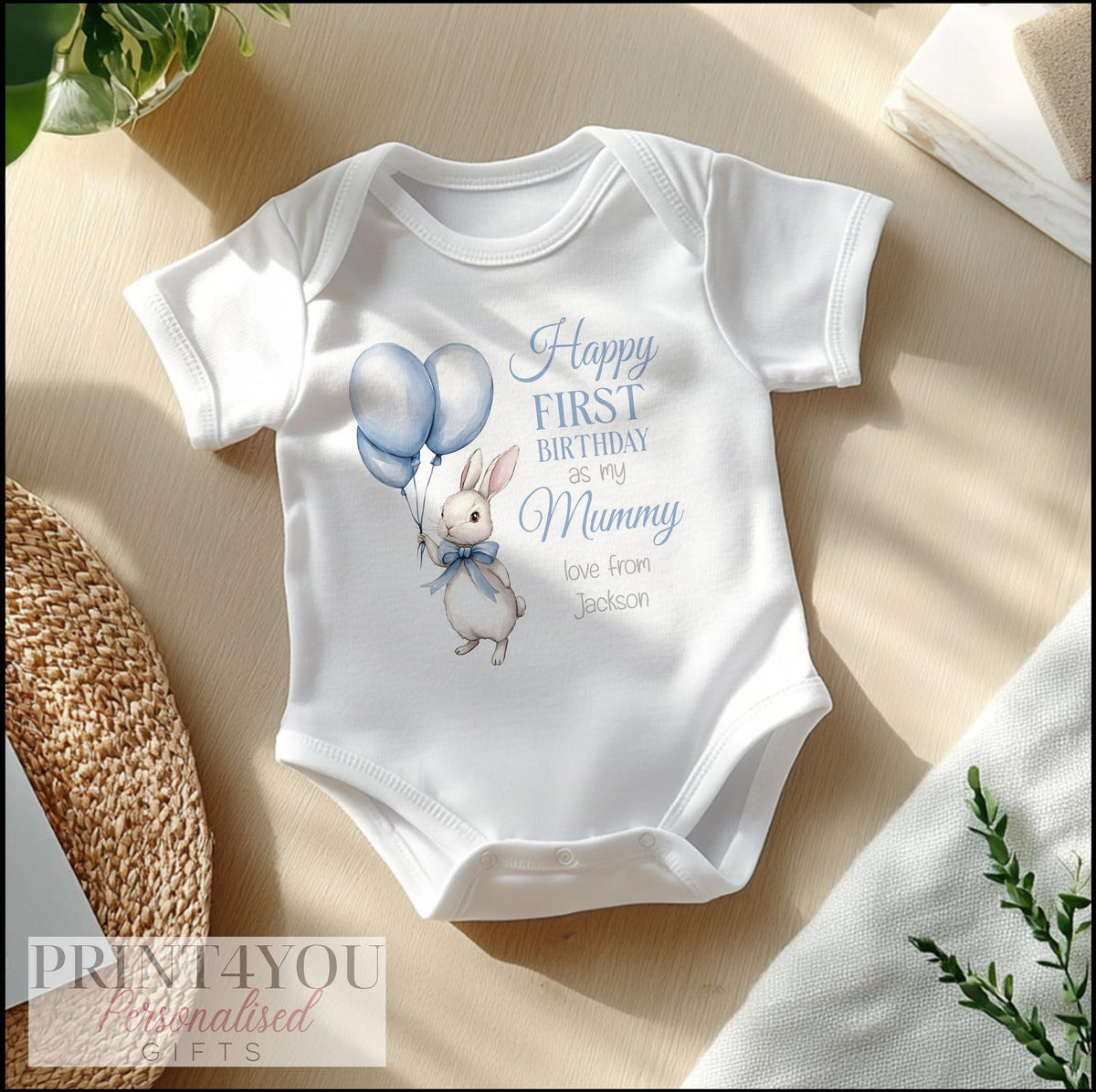 Personalised blue bunny first birthday sleepsuit, soft cotton printed with a chosen name and relation.