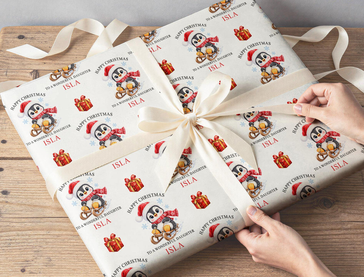 Gift wrapped in personalised penguin Christmas wrapping paper tied with a cream ribbon