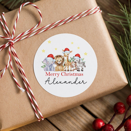 Gift box wrapped in red and white ribbon finished with a personalised glossy round safari animal Christmas sticker for Baby's First Christmas, printed with a custom name