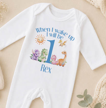 A white onesie with a personalized text and illustrations on it, specifically a dinosaur-themed design.