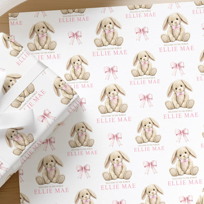 Flat lay of personalised pink bunny and teddy wrapping paper for a newborn with a name printed across the sheet