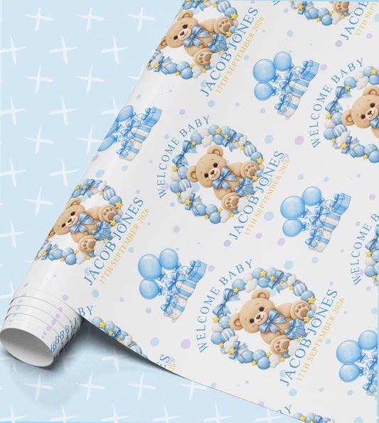 Personalised welcome baby wrapping paper with teddy bears, blue balloons and gift boxes, printed with Welcome Baby, the name Jacob Jones and the date 17th September 2026 on a light blue sparkle background