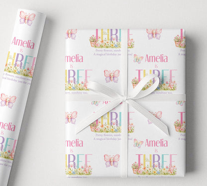 Personalised birthday wrapping paper with butterfly garden design, custom name and age, pastel flowers, soft rainbow colours and pretty birthday wording.