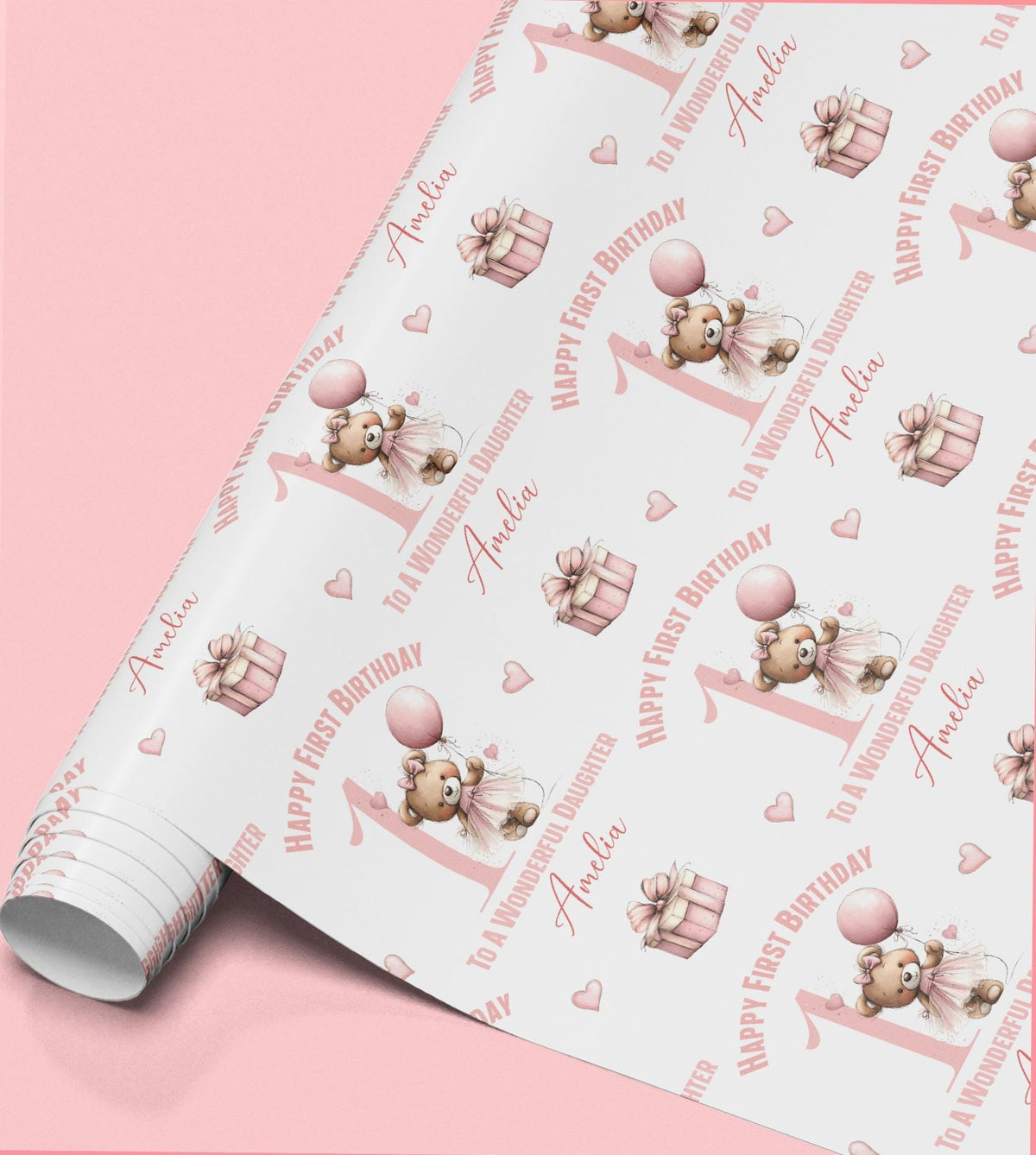 Roll of pink ballerina teddy bear wrapping paper printed with 'Happy First Birthday' and the personalised name Amanda, alongside gift box illustrations.