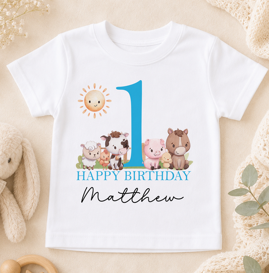 A white t-shirt with a graphic design featuring a blue number one, surrounded by various cartoon animal characters, and the text "Happy Birthday Matthew".