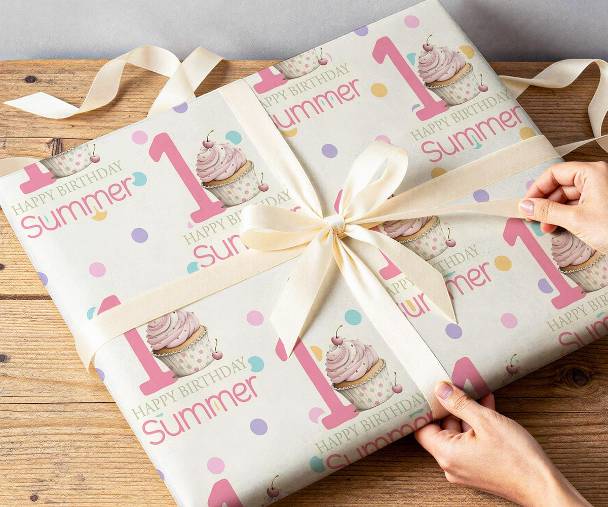 Close-up of hands wrapping a present in the personalised pink cupcake and confetti dot wrapping paper with white ribbon