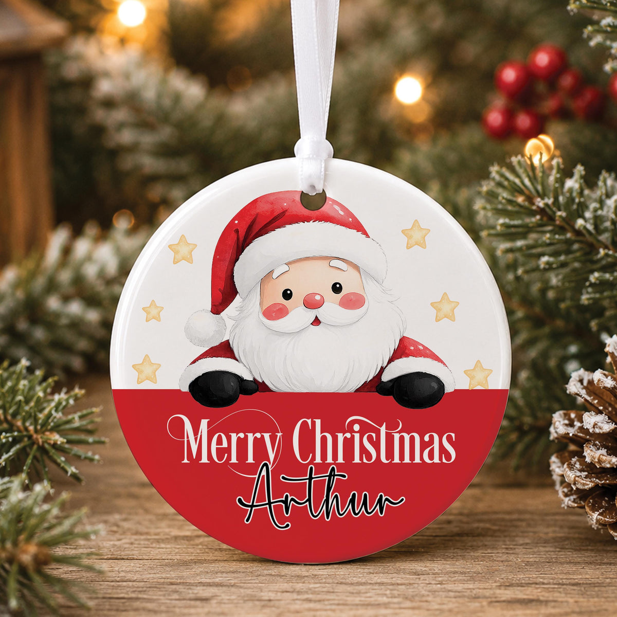 Personalised white ceramic Christmas bauble with Santa peeking over a red band, “Merry Christmas” and a name, hanging on a tree