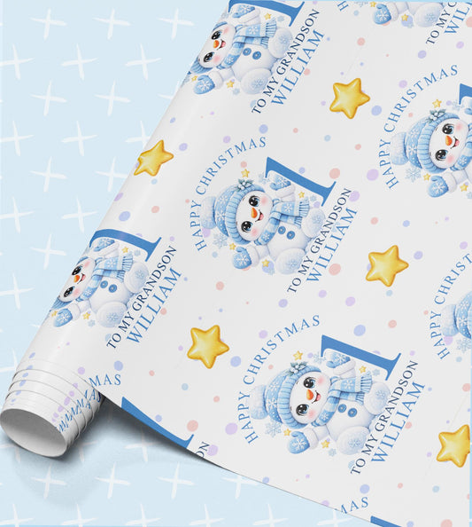 Personalised Christmas wrapping paper with baby snowmen in blue scarves, gold stars and snowflakes, printed with Happy Christmas, To My Grandson, the name William and the age 1 on a pale blue sparkle background