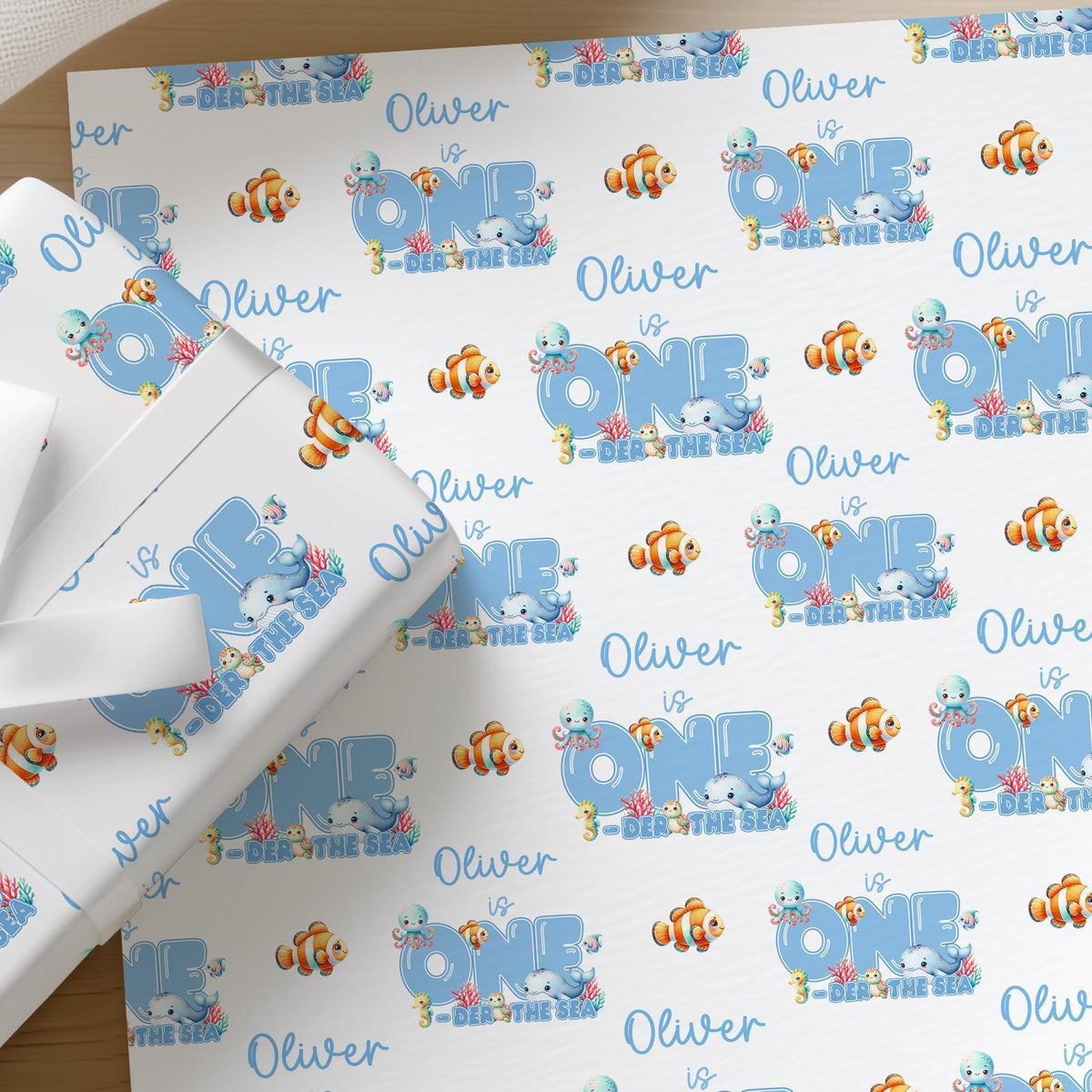 Roll of personalised under the sea wrapping paper with an example name printed on the design