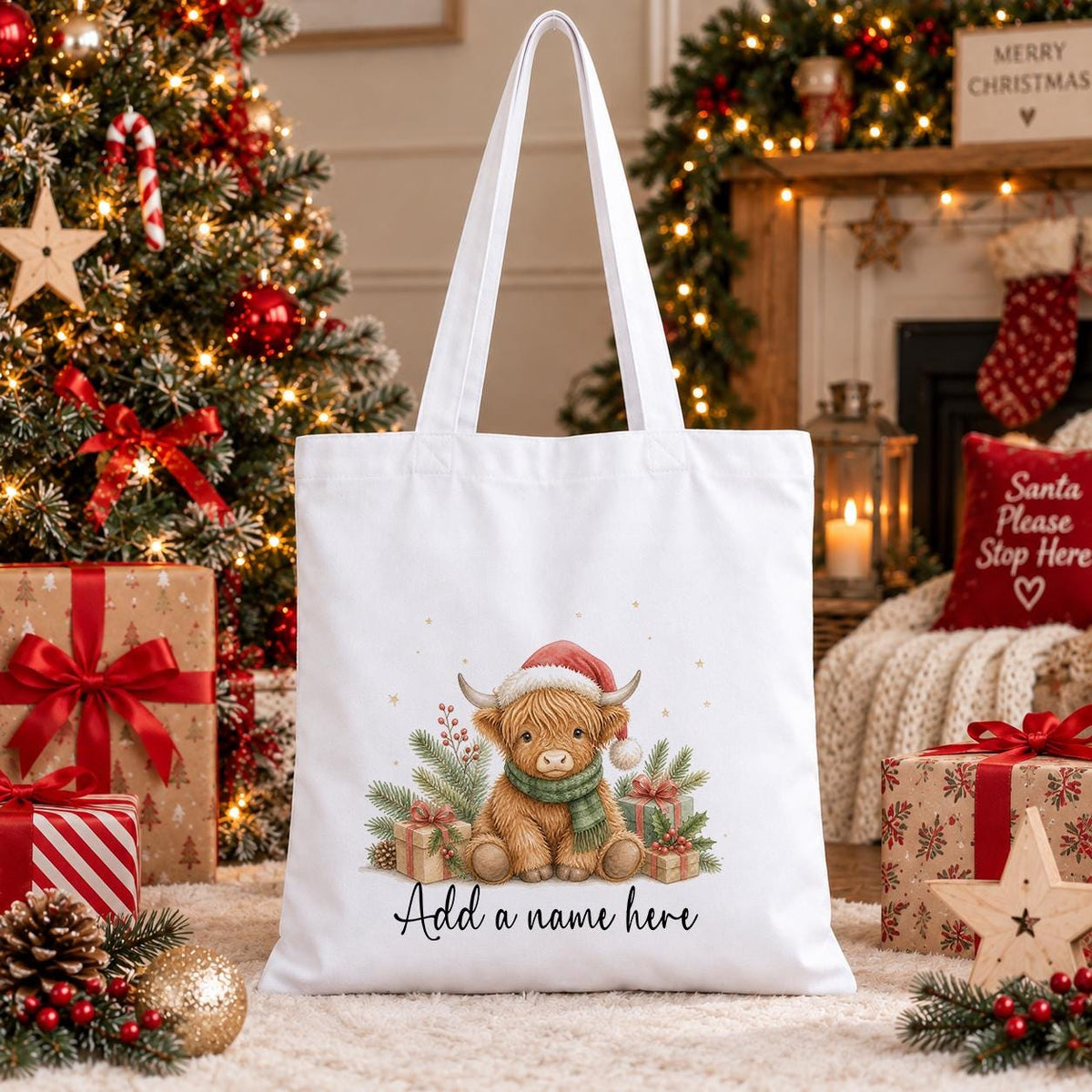 White cotton tote bag printed with a highland cow in a Santa hat and scarf among pine and berries, above a personalised name.