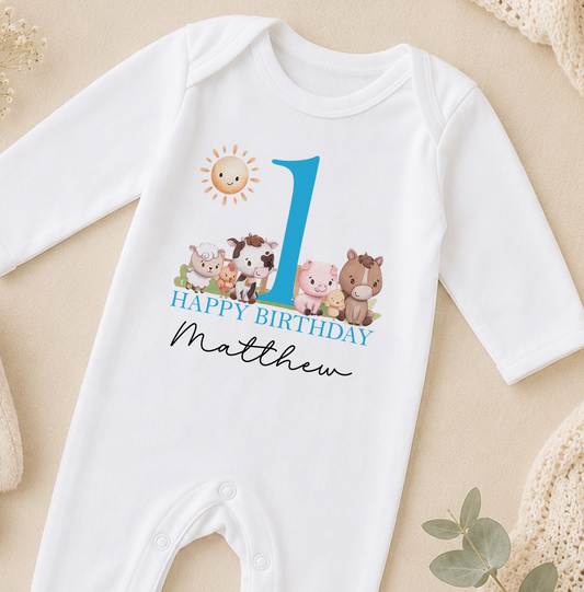 A white onesie with a blue number 1 and a cartoon image of farm animals, along with the text "Happy Birthday Matthew".