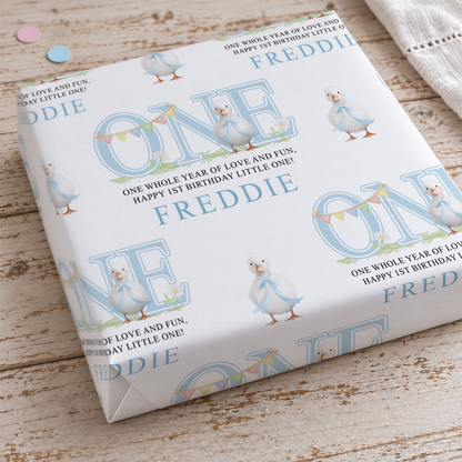 a white gift box with a repeating pattern of blue ducks and the name "FREDDIE" printed on it.