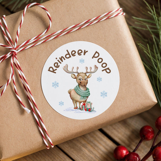 Reindeer Poop Christmas sticker with on a wrapped gift box with pine branches and berries