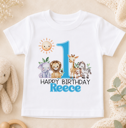 A white t-shirt with a printed design featuring a sun, a lion, a giraffe, and a zebra, along with the text "Happy Birthday Reece".
