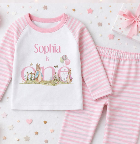 Personalised pink striped pyjamas with a grey bunny design and the child's name printed on the front