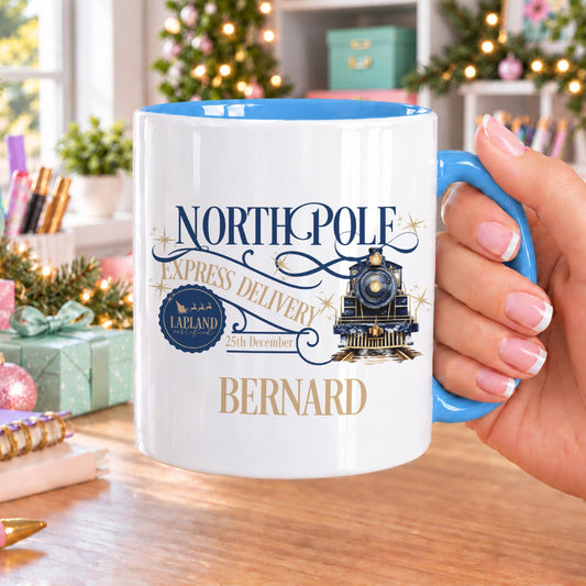 Personalised Christmas mug with blue handle and inside, printed with North Pole Express Delivery, a vintage steam train, a Lapland Certified stamp and 25th December postmark, with a name in gold