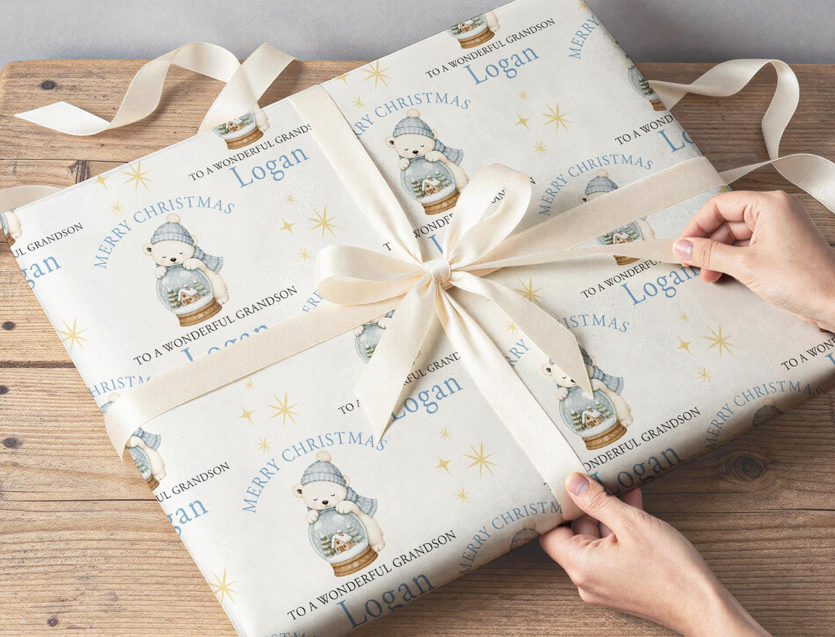 Personalised polar bear snow globe wrapping paper wrapped around a gift box under the Christmas tree.