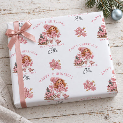Gift wrapped in personalised girl and sledge Christmas wrapping paper tied with a pink satin bow