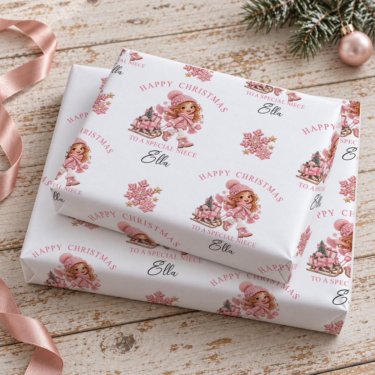 Two stacked gifts wrapped in personalised girl and sledge Christmas wrapping paper printed with the name Ella