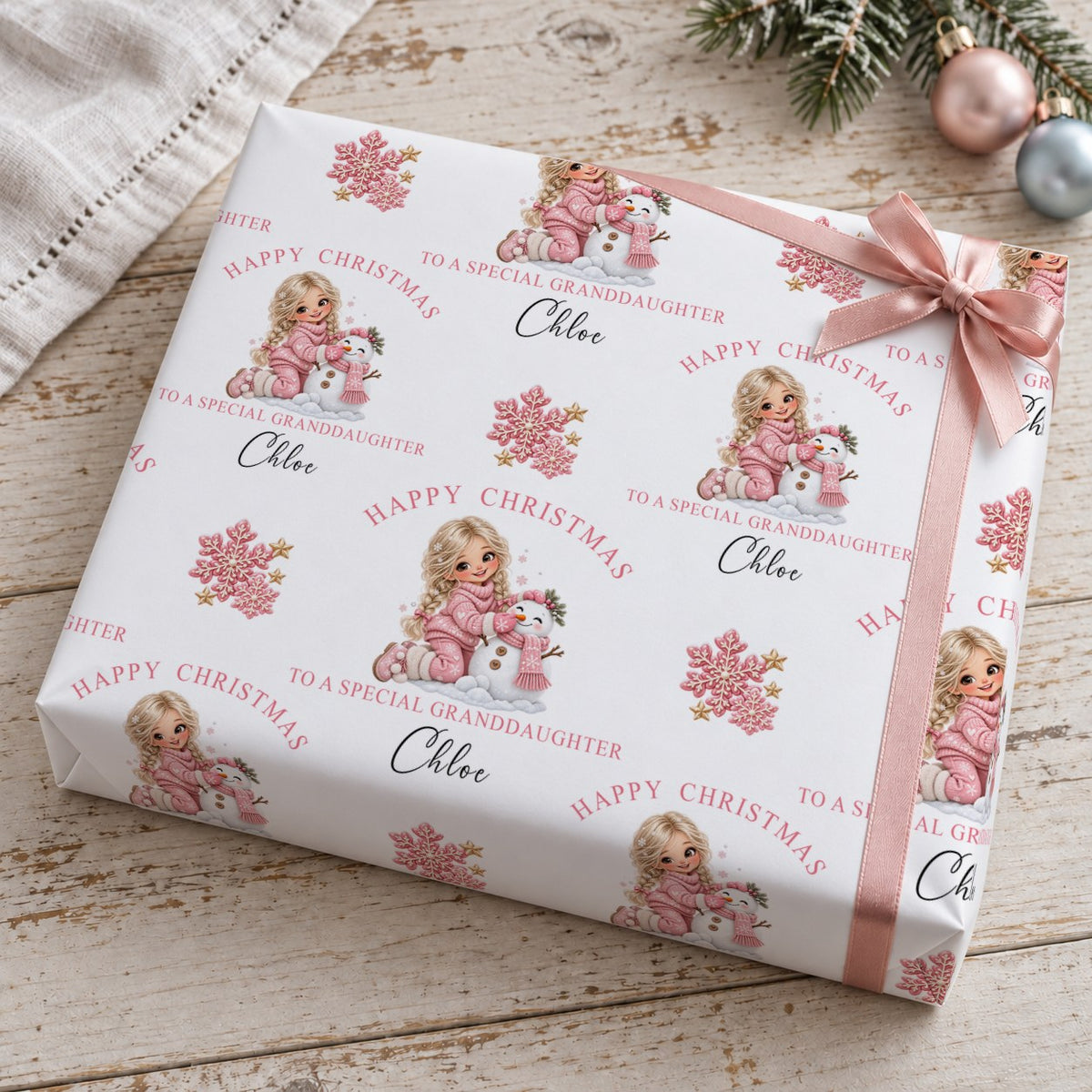 Present wrapped in personalised To A Special Granddaughter Christmas wrapping paper with a pink bow