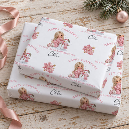 Two stacked gifts wrapped in personalised girl and snowman Christmas wrapping paper printed with the name Chloe