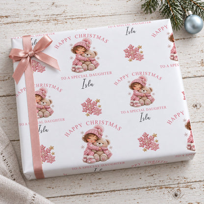 Gift wrapped in personalised girl and teddy bear Christmas wrapping paper tied with a pink satin bow