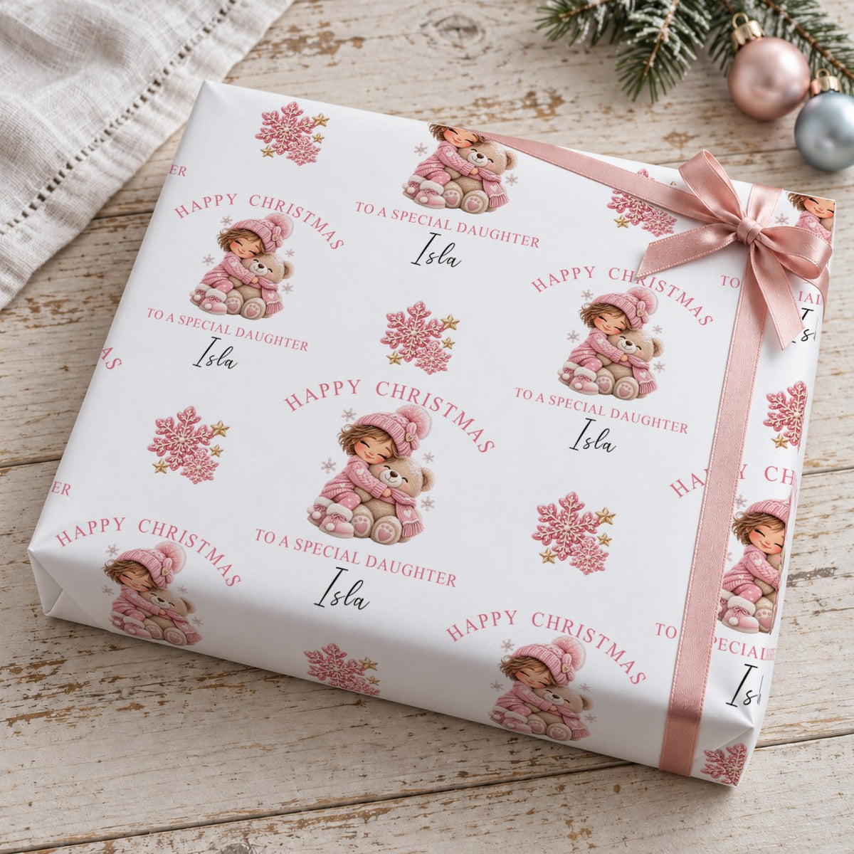 Present wrapped in personalised To A Special Daughter Christmas wrapping paper with a pink bow