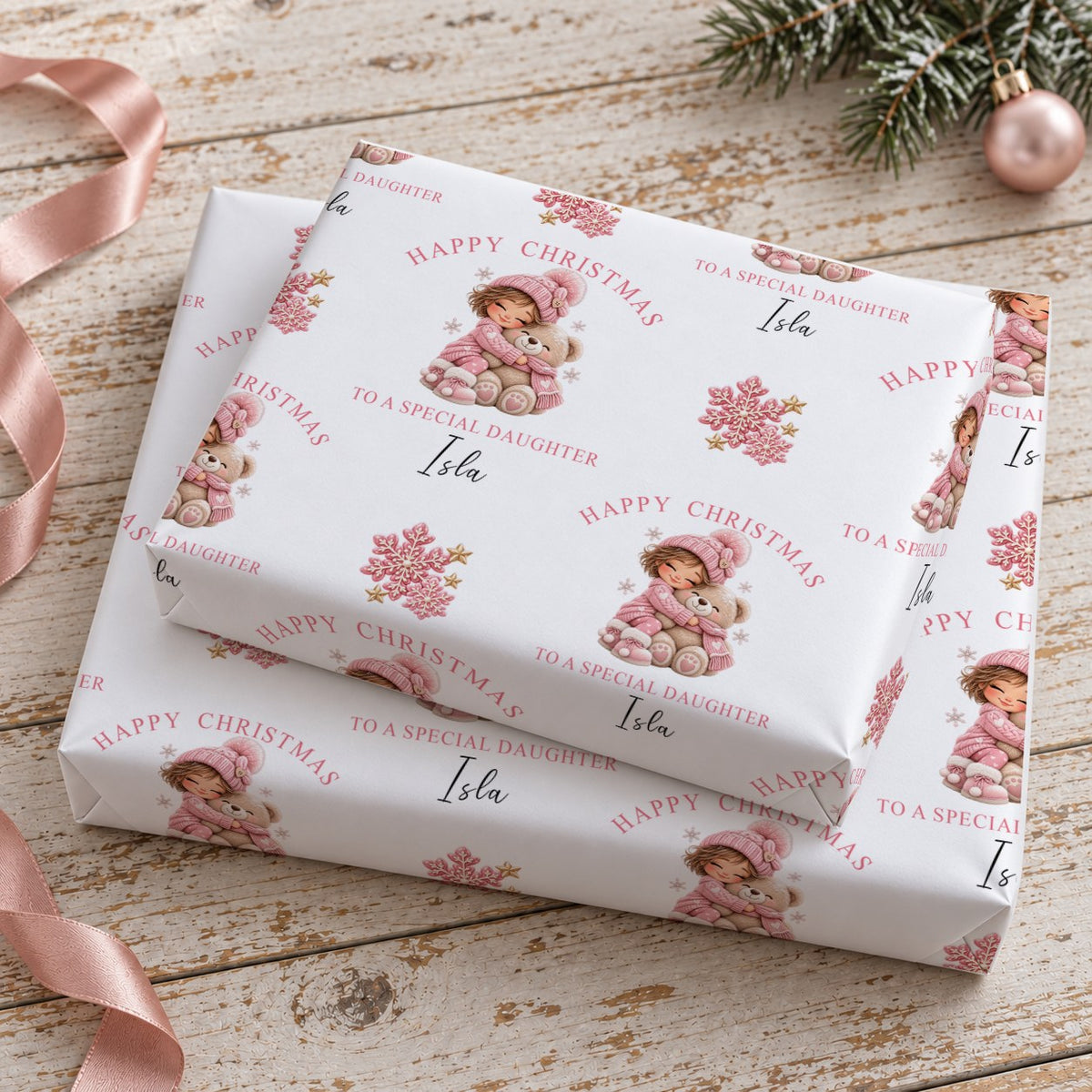 Two stacked gifts wrapped in personalised girl and teddy bear Christmas wrapping paper printed with the name Isla