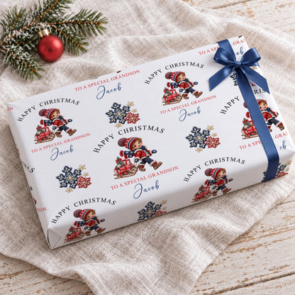 Gift wrapped in personalised grandson Christmas wrapping paper tied with a navy blue satin bow on a linen cloth