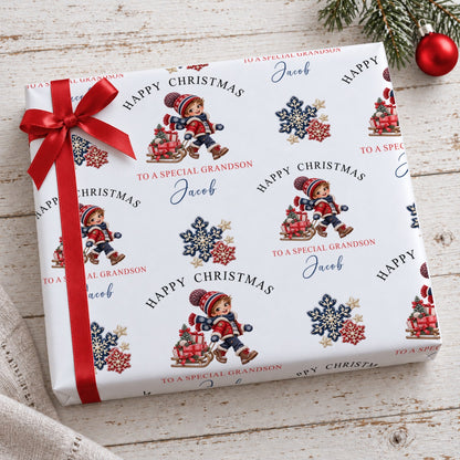 Present wrapped in personalised Happy Christmas To a Special Grandson Jacob paper with a red ribbon by a Christmas bauble