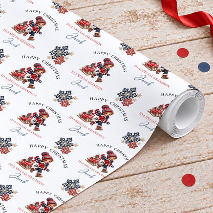 Personalised Christmas wrapping paper roll with a boy pulling a sledge of presents, Happy Christmas, To a Special Grandson and the name Jacob