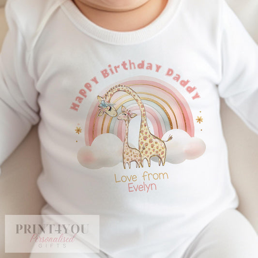 Personalised rainbow giraffe bib for a baby's first birthday, printed with 'Happy Birthday Daddy' and personalised with the baby's name in pink script.