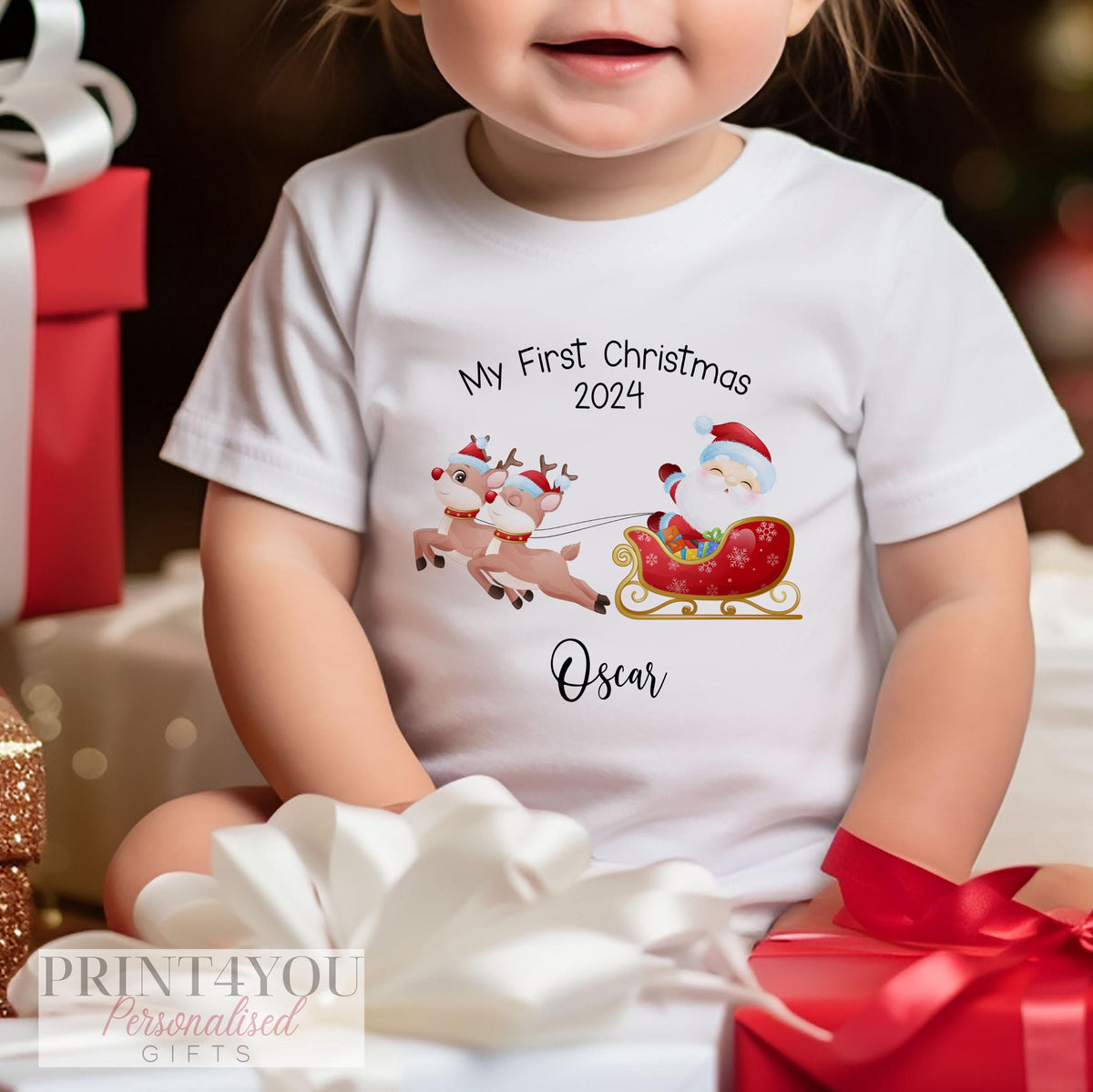 Personalised Santa and Reindeer Sleigh baby's first Christmas bib, vest and sleepsuit set folded flat, showing the full cotton range.