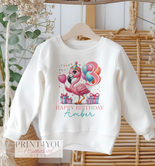Personalised flamingo birthday design on a white cotton kids' sweatshirt, size 6-12 months.