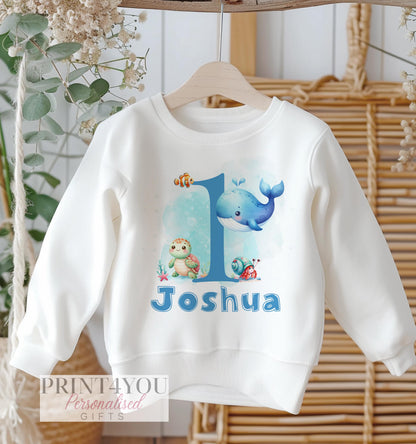 Blue long-sleeve baby sweatshirt with an under-the-sea design and personalised name, size 6-12 months