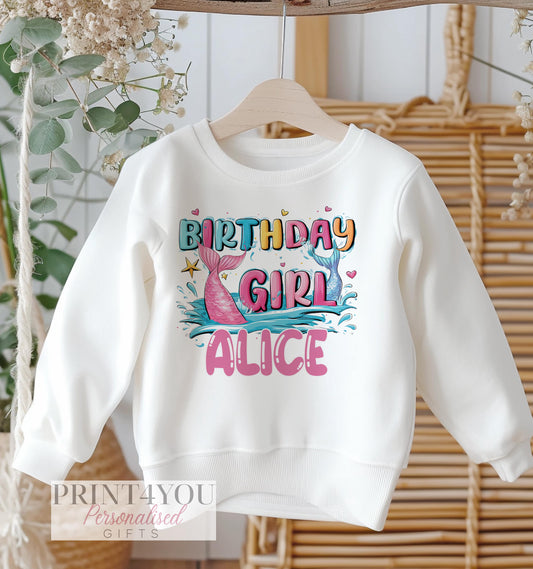 Personalised mermaid tail birthday design on a white cotton kids' sweatshirt, size 6-12 months.