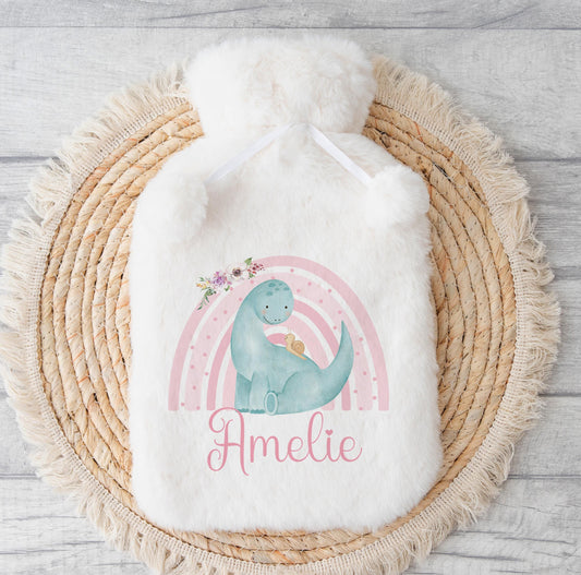 Fluffy white hot water bottle cover with a pastel rainbow dinosaur design, printed with the personalised name Amelie