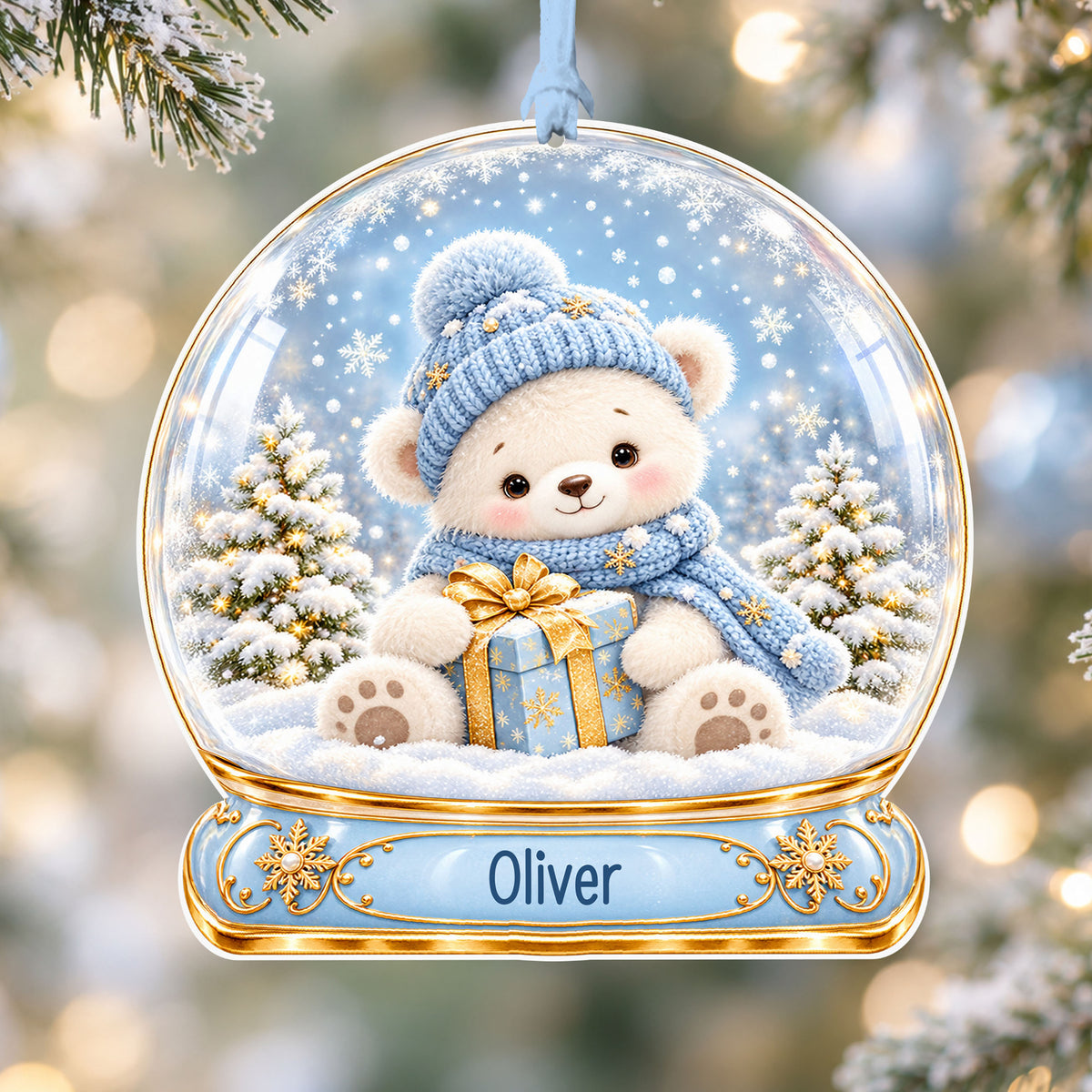 Personalised blue teddy acrylic snow globe Christmas bauble with custom name, hanging on a Christmas tree with baby blue ribbon