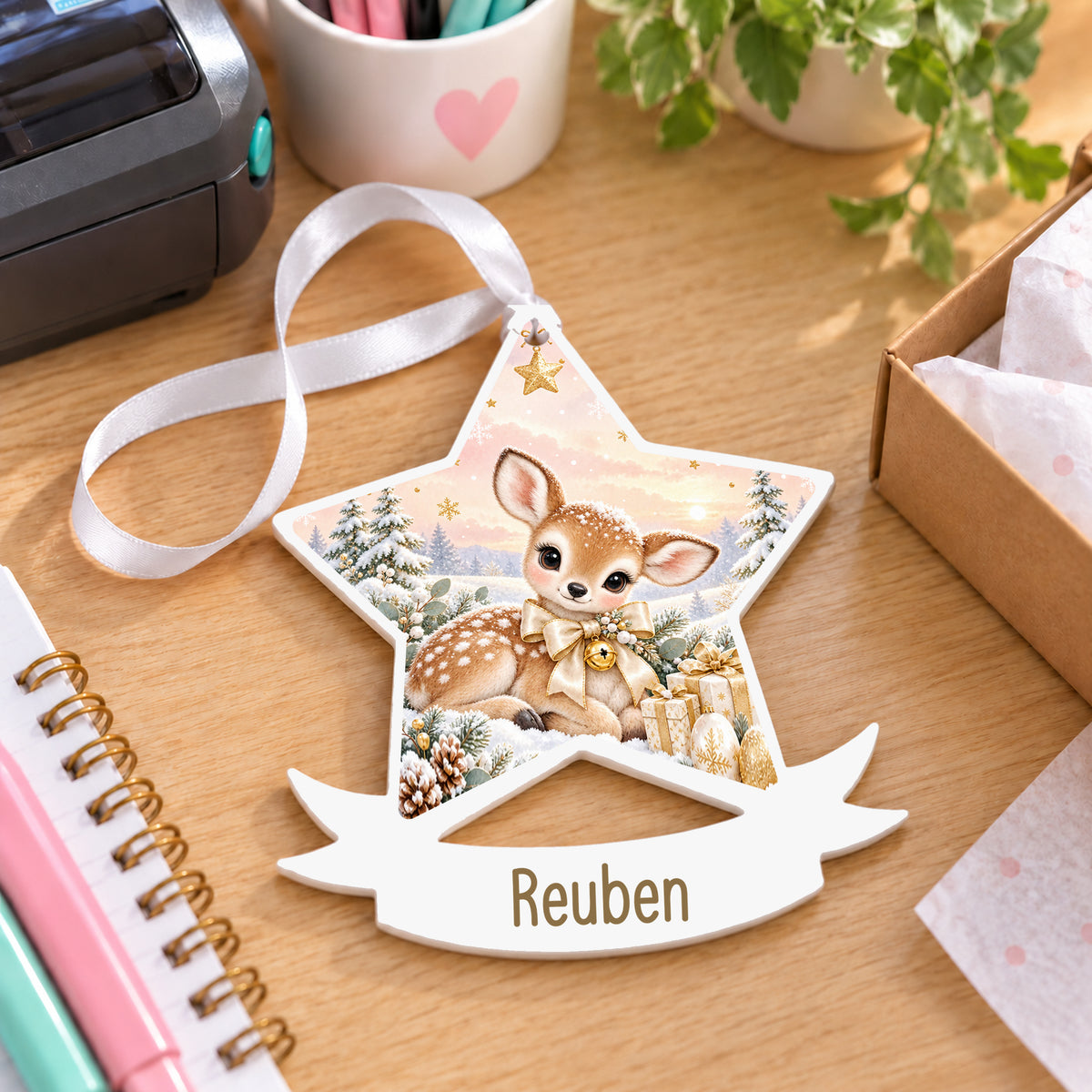 Personalised champagne fawn white acrylic star bauble with name, 10cm Christmas decoration with ribbon, shown on a desk