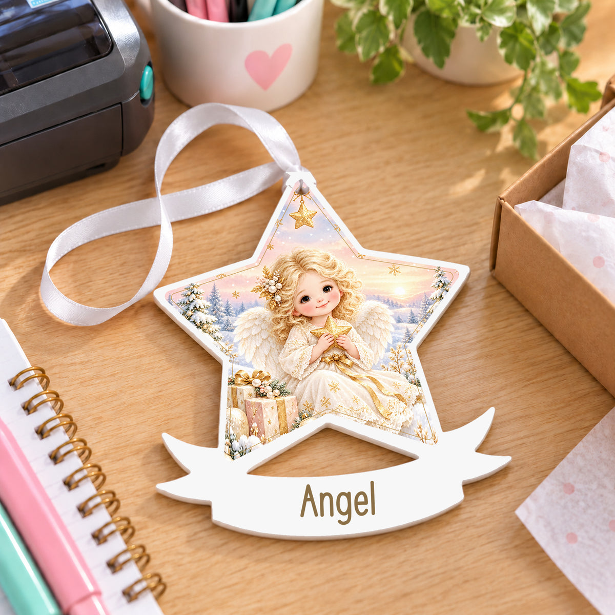 Personalised Christmas angel white acrylic star bauble with name, 10cm Christmas decoration with ribbon, shown on a desk