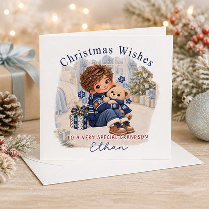 Personalised 6x6 Christmas Wishes card with a brown-haired boy in a navy snowflake jumper hugging his teddy bear by the tree, “To a very special grandson Ethan”